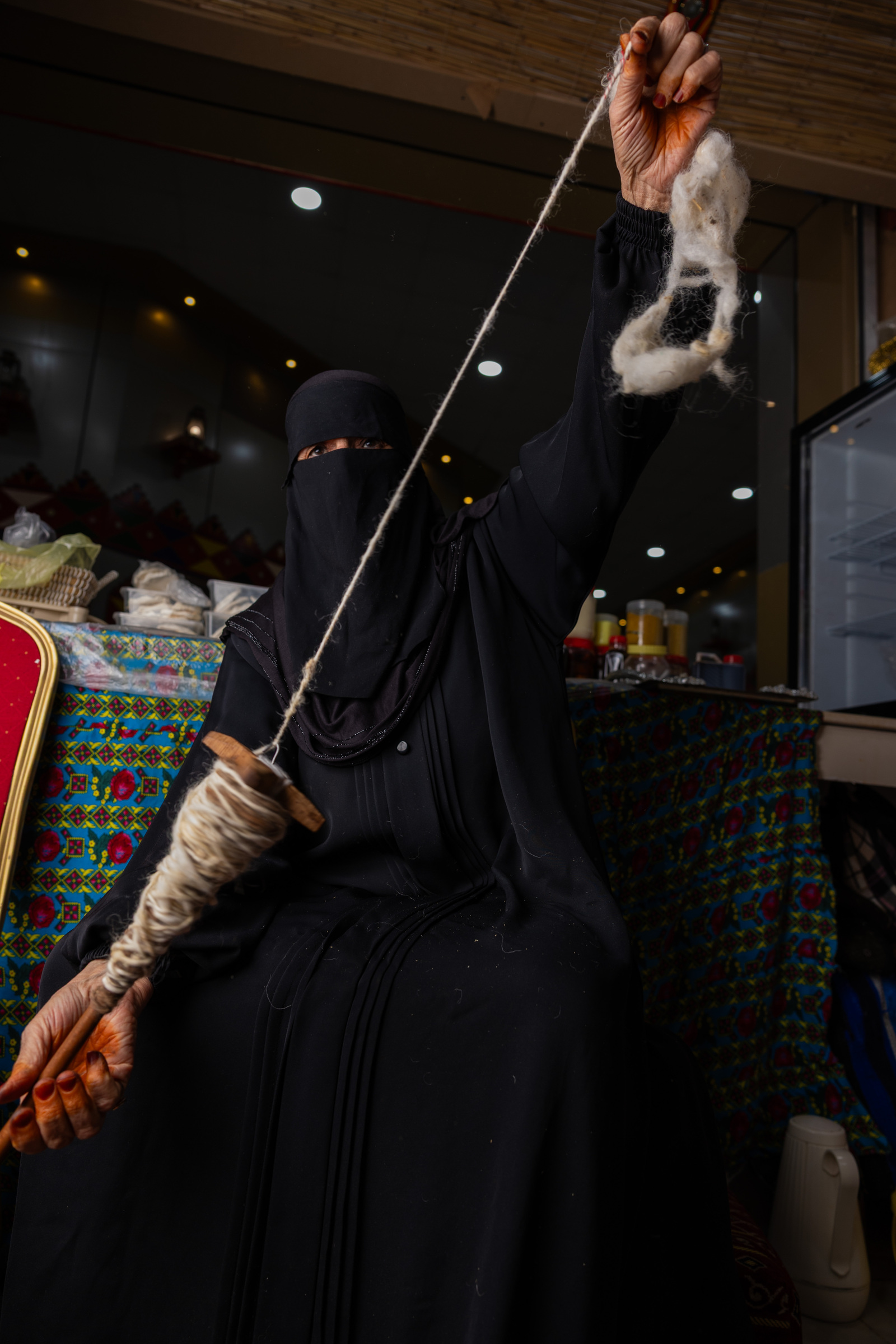 امرأة تغزل الخيوط بالمغزل.