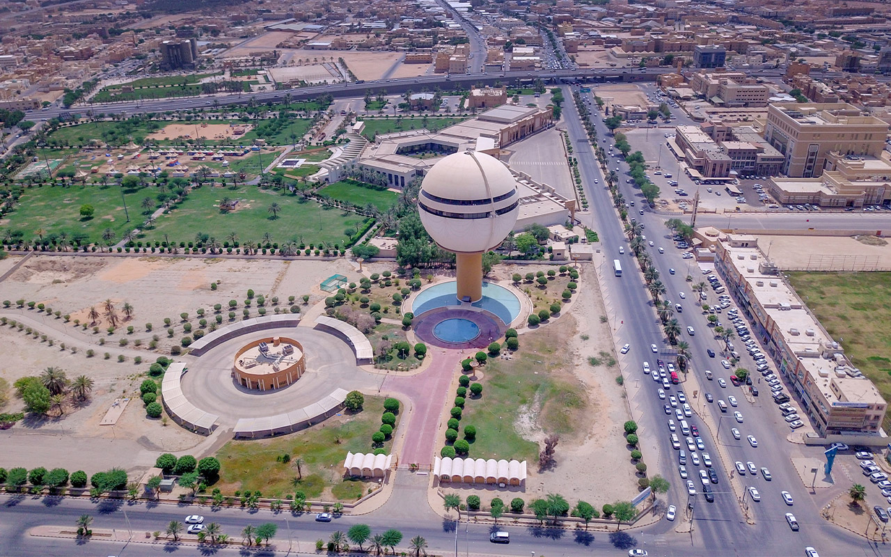 مشهد جوي لبرج مياه كروي ومتنزه وشارع رئيسي في القصيم.